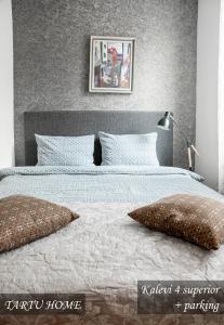 a bedroom with a large bed with pillows on it at Kvartal Delux, parking, Tartu Home in Tartu
