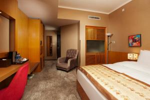 a hotel room with a bed and a chair at Ramada Ulaanbaatar City Center in Ulaanbaatar