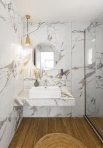 a white bathroom with a sink and a mirror at Yuka Villas Collection in Iraklitsa