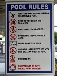 ein Schild, auf dem die Regeln des Pools stehen und keine Speisen oder Getränke im Poolbereich in der Unterkunft 1Bedroom SeaView StudioApartment in Kuah