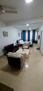 una sala de estar con sofás y sillas. en YoYo Goa, The Apartment Hotel, en Vagator