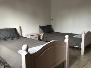 a bedroom with two beds and a night stand at Charmante villa située dans l’Est de l’île. in Village Sainte Anne