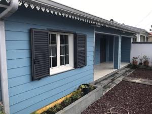 a blue house with a window on the side of it at Charmante villa située dans l’Est de l’île. in Village Sainte Anne