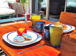 une table avec des plaques de beignets et deux verres de jus d'orange dans l'établissement Manuela Nogales Apartments!, à Malaga
