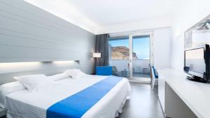 Habitación de hotel con cama y TV en Hotel Spa Calagrande Cabo de Gata, en Las Negras