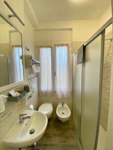 a bathroom with a sink and a toilet and a shower at Hotel Monna Lisa in Procchio