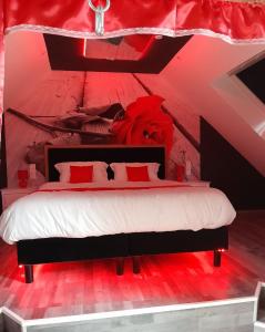 a bedroom with a large bed with red lighting at Love room le temps d'un plaisir in Landisacq