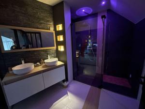 a bathroom with two sinks and a walk in shower at Love room le temps d'un plaisir in Landisacq