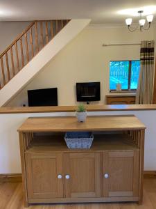 a living room with a table and a staircase at Little Nest EV Point in Wadebridge