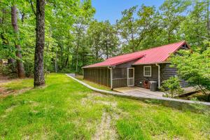 a cabin in the woods with a red roof at Wild Rose Cabin in Lake Lure