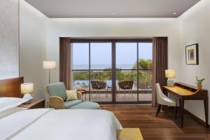 Sheraton Grand Chennai Resort & Spa في مهاباليبورام: غرفة في الفندق بها سرير ومكتب ومكتب