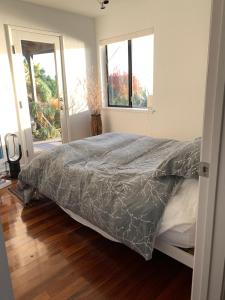 ein Schlafzimmer mit einem Bett mit einer grauen Bettdecke in der Unterkunft Spectacular SF Bay Front House with Dramatic Views in Richmond