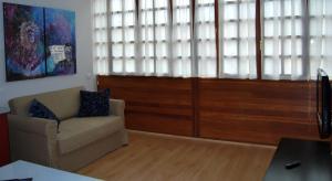 un soggiorno con divano e una grande finestra di Apartamentos Plaza Mayor a Llanes