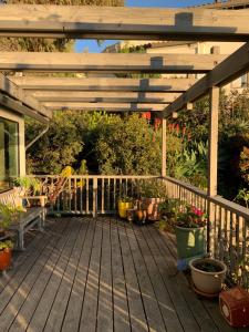 eine Holzterrasse mit einer Pergola und einigen Pflanzen in der Unterkunft Spectacular SF Bay Front House with Dramatic Views in Richmond