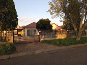 a wooden fence in front of a house at Lux contractors accommodation in Bronkhorstspruit