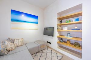 un soggiorno con divano e TV a schermo piatto di Carioca Kiwi House - Centro Histórico a Tarifa