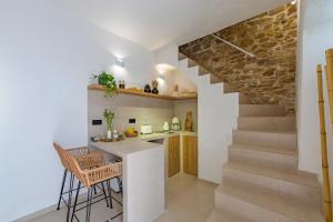 a kitchen and dining area with a counter and a staircase at Carioca Kiwi House - Centro Histórico in Tarifa