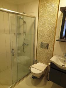 a bathroom with a shower and a toilet and a sink at Emirhan Inn Apart Hotel & Suites in Istanbul