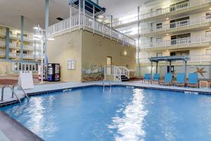 einem Pool in der Mitte eines Gebäudes mit blauen Stühlen in der Unterkunft Hilton Head Resort 4226 in Hilton Head Island