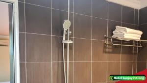 y baño con ducha con cabezal de ducha. en Hotel Sunjoy9 Klang, en Klang
