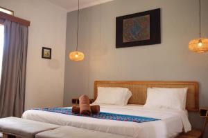 a teddy bear sitting on a bed in a bedroom at Tentacle Bali in Nusa Penida