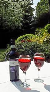 a bottle of wine and two glasses of red wine at Maywalk House B&B in Eyam