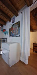 uma cómoda branca num quarto com uma pintura na parede em Apartment mYourHome em Catânia