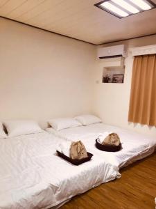 2 letti in una camera con lenzuola bianche di Starry Sky Hostel a Checheng