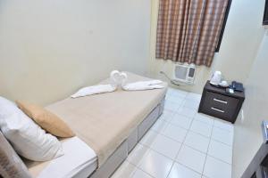 Una habitación con una cama con toallas. en Amax Inn Makati en Manila