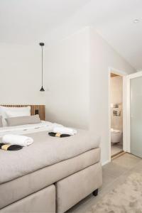 a white bedroom with a bed and a bathroom at Pellinge Marina in Porvoo