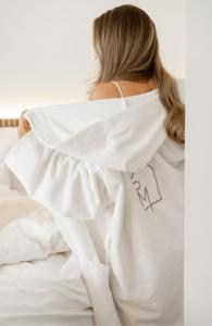 une femme qui se couche au lit et porte une chemise blanche dans l'établissement Pellinge Marina, à Porvoo