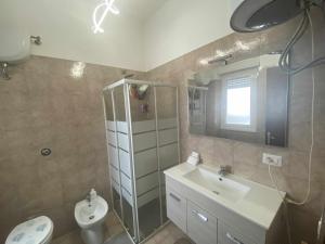 een badkamer met een wastafel, een toilet en een spiegel bij Seamoon Home Nettuno in Nettuno +16 foto's