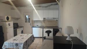 a kitchen with white cabinets and a black counter top at Studio charmant in Fontenay-sous-Bois