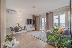 a living room with a couch and a table at Apartament Kameralis Old Town - klimatyzacja - balkon - winda in Elblag