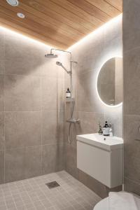 ein Bad mit einer Dusche, einem Waschbecken und einem Spiegel in der Unterkunft Pellinge Marina in Porvoo