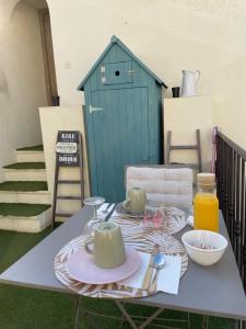 a table with two mugs on it with a blue shed at Ô 36 Rempart Sud B&B in Aigues-Mortes
