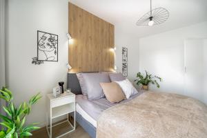 a bedroom with a bed with a wooden headboard at Apartament Kameralis Old Town - klimatyzacja - balkon - winda in Elblag