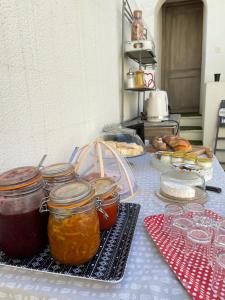 - une table avec des bocaux de confiture et d'autres aliments dans l'établissement Ô 36 Rempart Sud B&B, à Aigues-Mortes