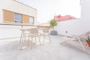 um pátio com uma mesa e cadeiras num edifício em Moott Homes Suites Casa de los Leones APTO 1 em Almeria