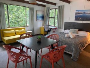 a room with a bed and a table and chairs at Mountain Creek Vacation in Queenstown