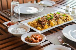 una mesa con platos y tazones de comida. en Malala Retreat, en Hambantota