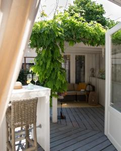 un patio al aire libre con pérgola, mesa y sillas en Suite 137, luxe verblijf midden in de bollenstreek, en Lisse