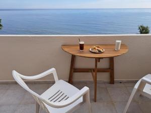 een tafel met een bord eten en drinken bij Nettuno Seafront Apartments in Análipsis