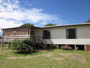 a large white house with a porch and a yard at Beachcomber Bliss in Smiths Beach