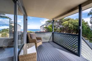 a balcony with two chairs and a table on it at Eagles Rest in Coles Bay