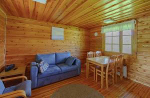 a living room with a blue couch and a table at Rauhalahti Holiday Cottages in Kuopio