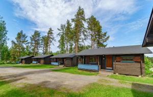 a row of wooden cabins with trees in the background at Rauhalahti Holiday Cottages in Kuopio