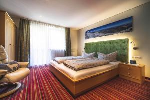 ein Schlafzimmer mit einem großen Bett und einem Sofa in der Unterkunft Alpenherz Apartments in Sankt Gallenkirch
