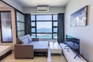 a living room with a couch and a large window at Margo Home - Jesselton Quay in Kota Kinabalu