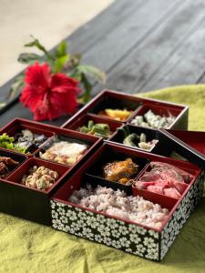 drei Tabletten mit verschiedenen Arten von Lebensmitteln auf einem Tisch in der Unterkunft Taketomijima Akaneya in Taketomi
